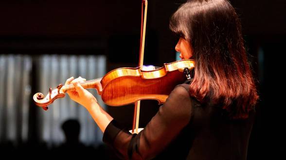 photo d'une femme de dos jouant du violon